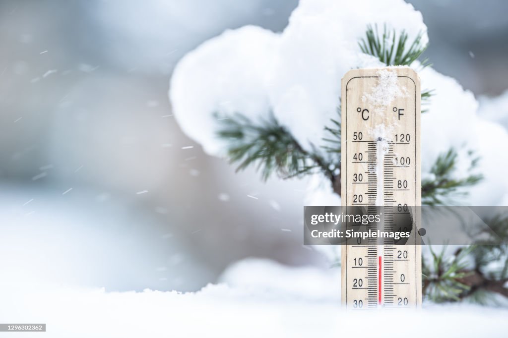 Thermometer in the snow shows low temperatures in Celsius and Farenhaits.