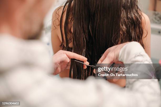 man cutting woman's long brown hair - cabelo-humano imagens e fotografias de stock