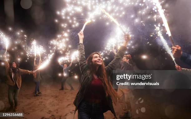 grupo de amigos jugando con bengalas en la playa - bengala fuego artificial fotografías e imágenes de stock