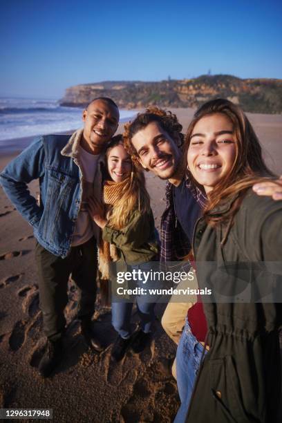 freundesgruppe macht selfie am strand bei sonnenuntergang - funkwelle stock-fotos und bilder