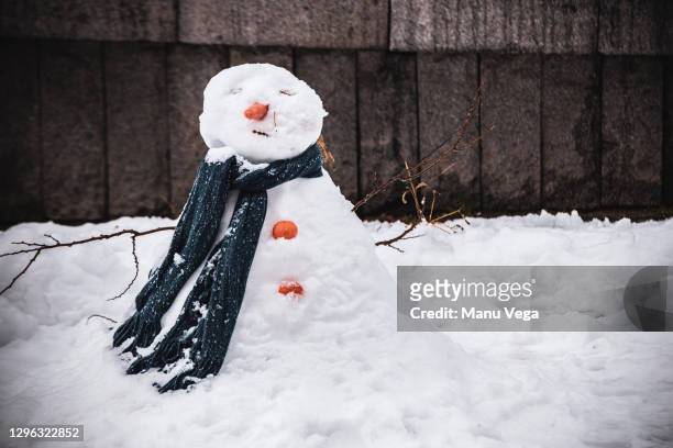 snowman built on city street - melting snowman stock pictures, royalty-free photos & images