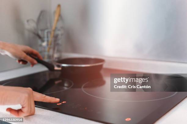 close up of woman using induction stove in kitchen - placa de fogão vitrocerâmica - fotografias e filmes do acervo