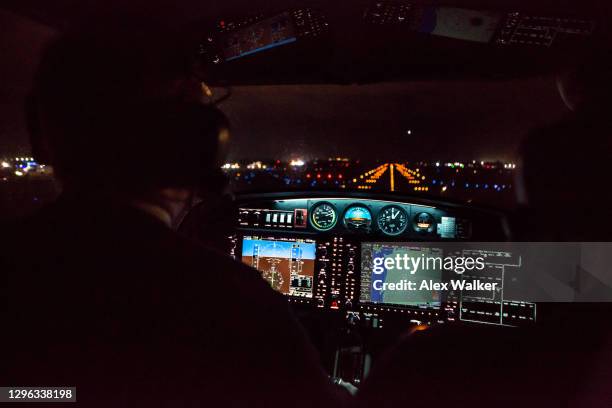 pilot in cockpit of small private aircraft landing at night. - höhenmesser stock-fotos und bilder