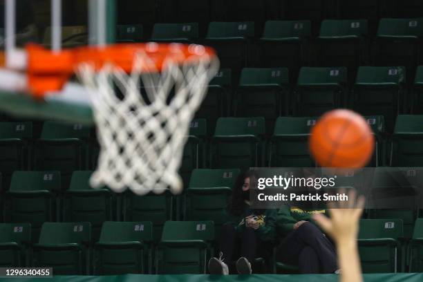 Fans wearing protective face coverings due to the Covid-19 pandemic watch play between the George Mason Patriots and the La Salle Explorers during an...