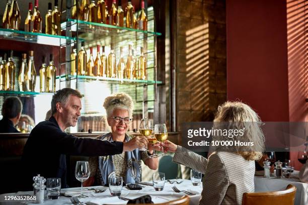 friends toasting with wine in restaurant - friends in restaurant bar stock pictures, royalty-free photos & images
