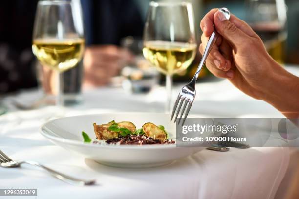man eating meal at table with fork - gourmet eten stockfoto's en -beelden