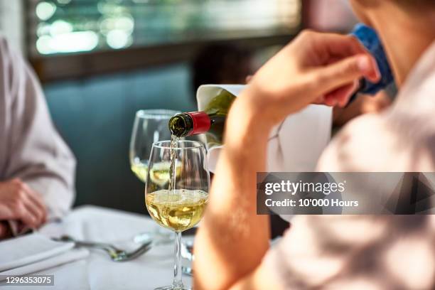 close up of waiter pouring white wine - chardonnay grape stock pictures, royalty-free photos & images
