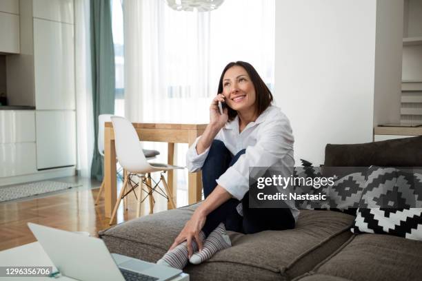vacker ung kvinna som pratar på smart telefon hemma - öra bildbanksfoton och bilder