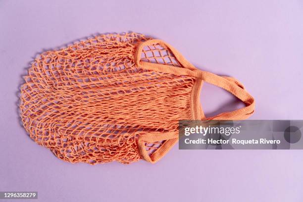 reusable orange fabric shopping bag on purple background, concept free of plastic and recycling, care of the planet and climate change - reusable bag isolated stock pictures, royalty-free photos & images