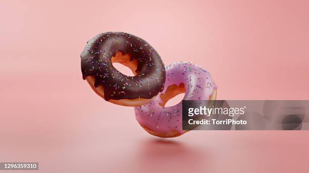 pink and chocolate donuts on pink background - pop fly fotografías e imágenes de stock