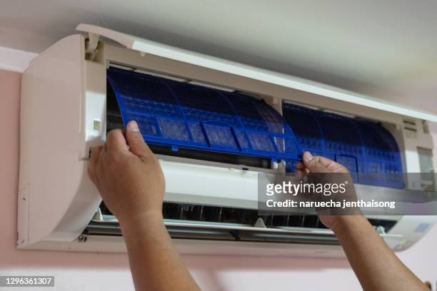 male technician cleaning air conditioner indoors - air cooler stock pictures, royalty-free photos & images