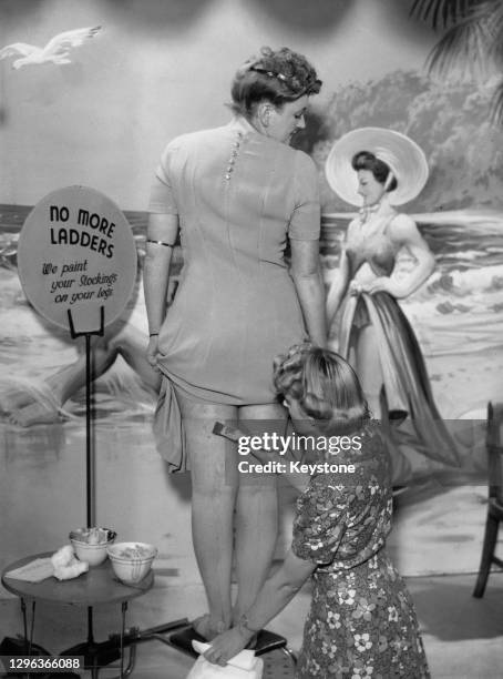 Beautician at the newly-opened Bare Leg Beauty Bar at Kennard's store in Croydon, painting a customer's legs to imitate actual silk and nylon...