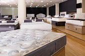 Closeup of new modern orthopaedic mattress on display for sale in large furniture store