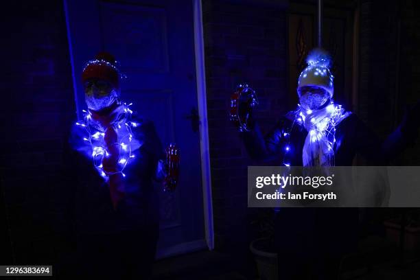 Two residents from the same household wear fairly lights as they take part in the Clap for Heroes event on January 14, 2021 in Saltburn-by-the-Sea,...