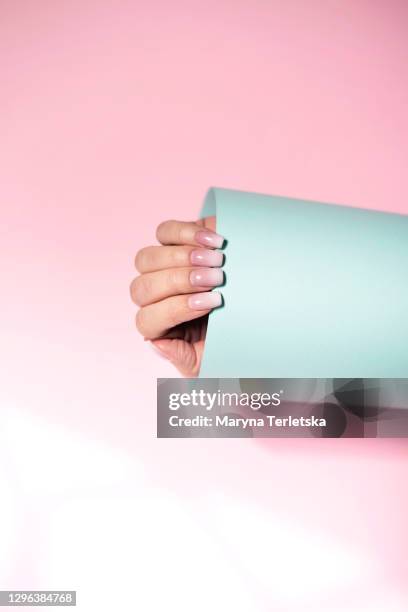 female hand with a beautiful manicure on a pink background. - pink ombre stock pictures, royalty-free photos & images