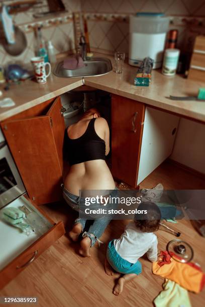 high angle view of mother and daughter repairing - under sink stock pictures, royalty-free photos & images