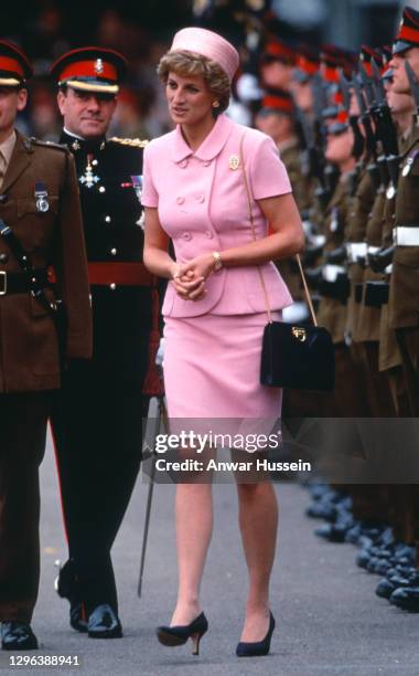 Diana, Princess of Wales, wearing a pink suit designed by Versace and a pillbox hat by Philip Sommerville, inspects members of the Queen's and Royal...