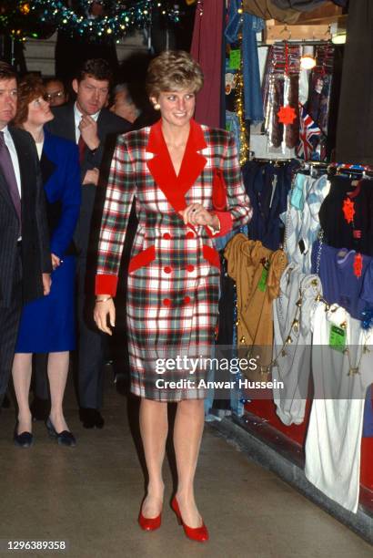 Diana, Princess of Wales, wearing a red and green tartan coat dress designed by Catherine Walker with red heels, opens the The Galleries shopping...