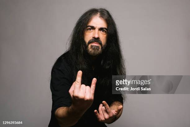 portrait of a heavy metal man doing rock symbol with his hands - heavy metal stock pictures, royalty-free photos & images