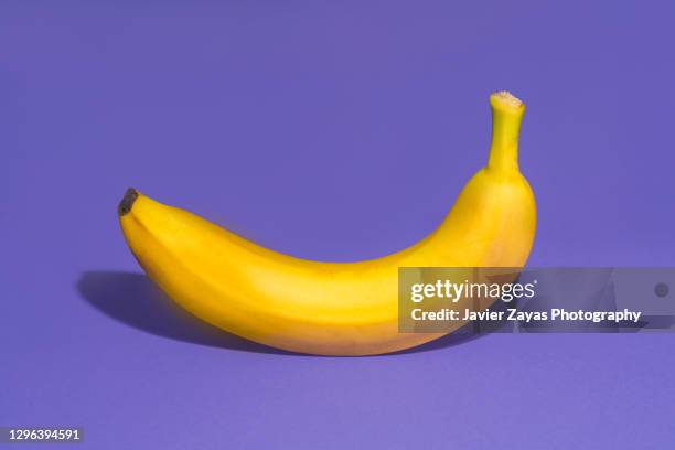banana on a purple background - banaan stockfoto's en -beelden