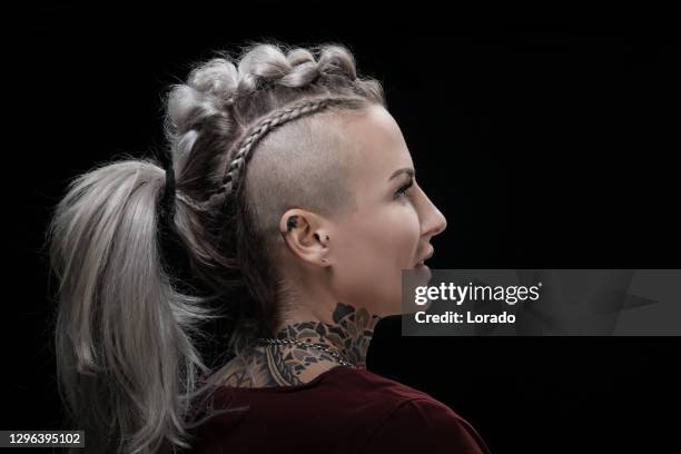 retrato lateral de una mujer rubia vikinga tatuada y su peinado único - corte de pelo con media cabeza rapada fotografías e imágenes de stock