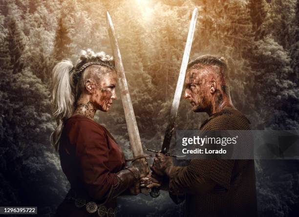 blood and mud covered viking warrior couple in studio shot - blood covered stock pictures, royalty-free photos & images