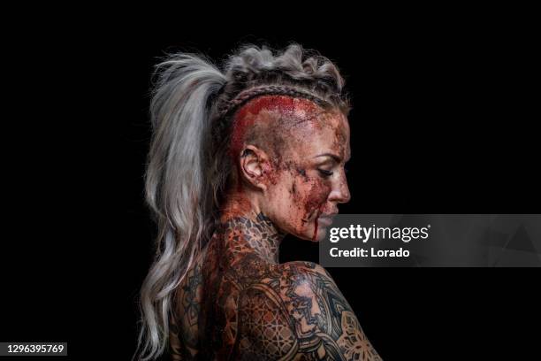 portret van een bloed en modder behandelde de krijgerkoningin van viking in studioschot - viking warrior stockfoto's en -beelden