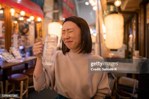 仕事の後、居酒屋のバーでアルコールに満足した若い女性 - 居酒屋 ストックフォトと画像