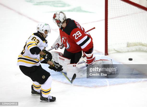 Brad Marchand of the Boston Bruins scores the game winning goal past Mackenzie Blackwood of the New Jersey Devils during the home opening game at...