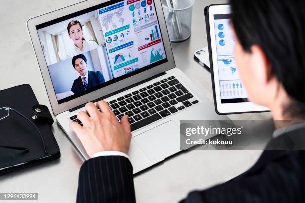 a businessman wearing suits are doing online meeting with grouops in office - business man smartphone tablet stock pictures, royalty-free photos & images