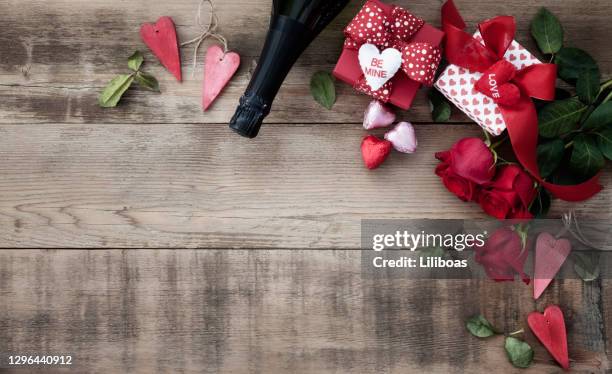 valentine's day roses and chocolates on a wood background - champange bottle and valentines day stock pictures, royalty-free photos & images