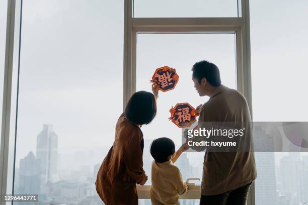 asian family decorating home and prepare for chinese new year - ceremony stock pictures, royalty-free photos & images