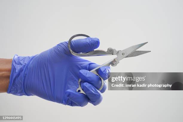 hand with latex glove holding scissors - surgical scissors stock pictures, royalty-free photos & images