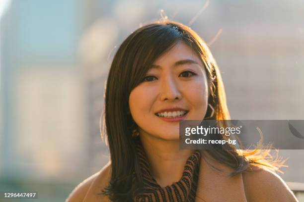 zurück beleuchtet porträt der schönen frau bei sonnenuntergang in der stadt - only japanese stock-fotos und bilder