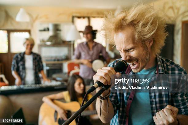 grito de rockero enojado macho en el micrófono - heavy metal fotografías e imágenes de stock