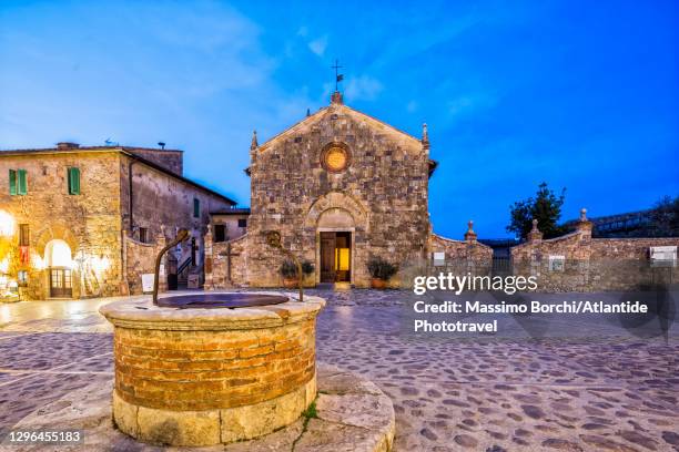 the well and the chiesa (church) di santa maria assunta in the main square - monteriggioni stock pictures, royalty-free photos & images