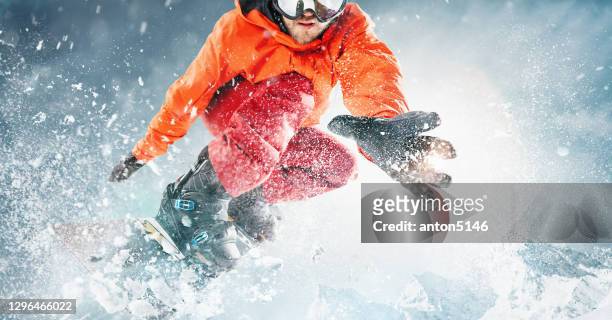 snowboarder jumping through air with deep blue sky in background. the snowboarding sportsman flying in snow action and motion - snowboard imagens e fotografias de stock