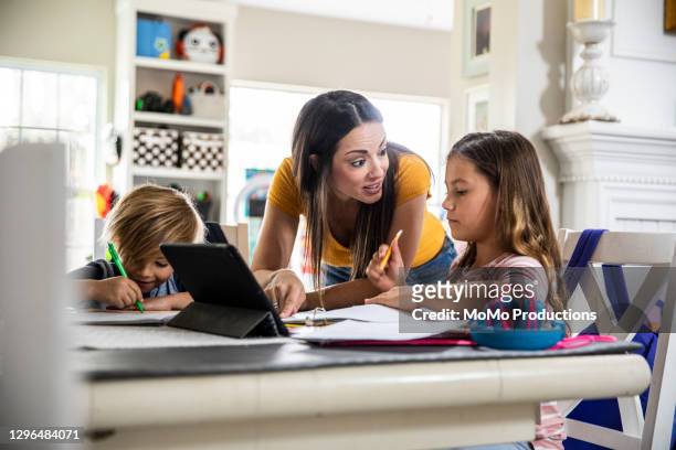 mother working from home and homeschooling children - learning generation parent child stock-fotos und bilder
