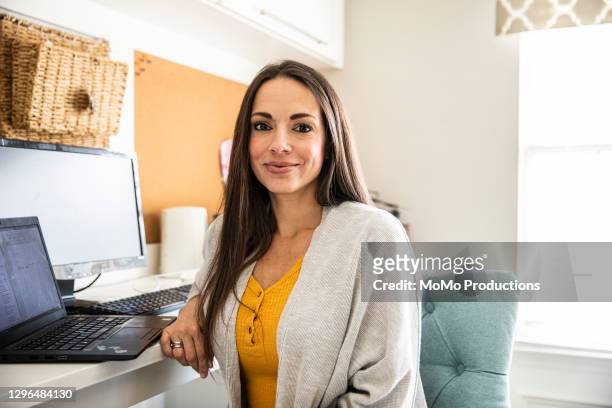 portrait of businesswoman in home office - hispanic woman stockfoto's en -beelden