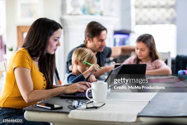 mother working from home while children attend school online - mother and son using tablet and laptop stock pictures, royalty-free photos & images