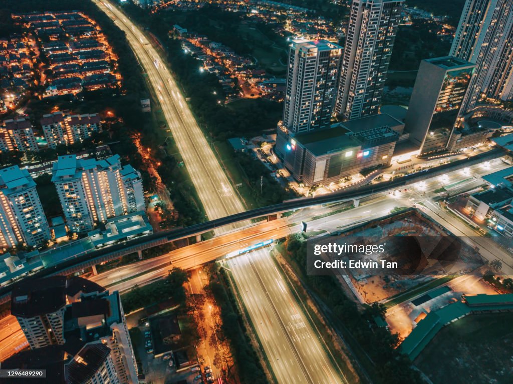 Drone point of view directly above downtown district at night with powerline and illuminated by street lights