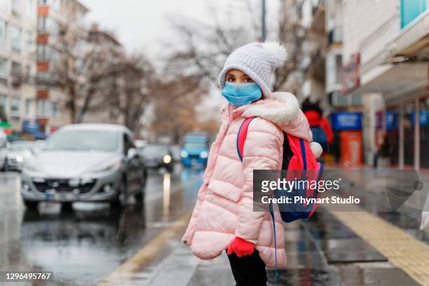 meisje dat anti virusmaskers draagt die naar school gaan - cross road children stockfoto's en -beelden