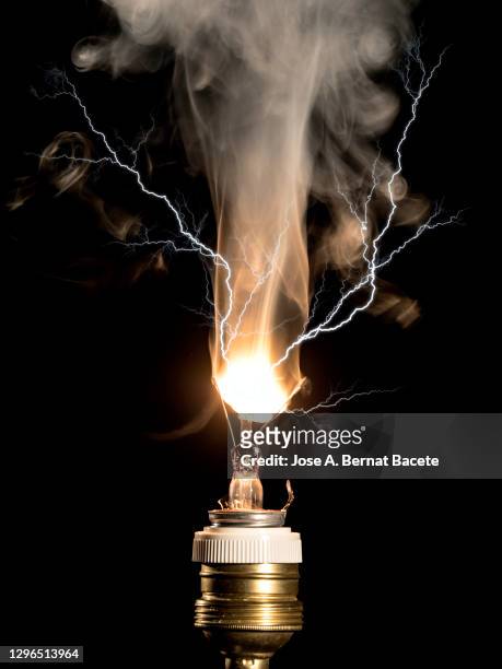burning light bulb filament with an electric explosion on a black background. - broken lamp stockfoto's en -beelden