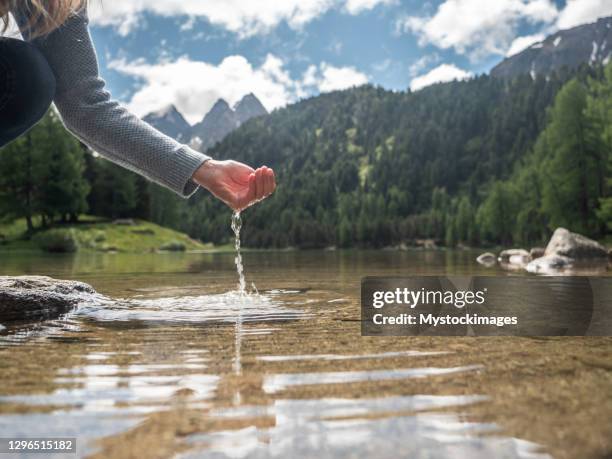 hands scooping water from alpine lake - body detox stock pictures, royalty-free photos & images