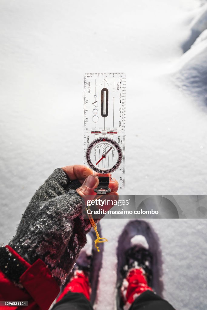 Hiking, detail of hand with compass for orientation in the mountains