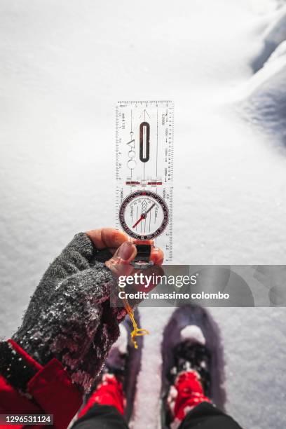 hiking, detail of hand with compass for orientation in the mountains - east stock pictures, royalty-free photos & images