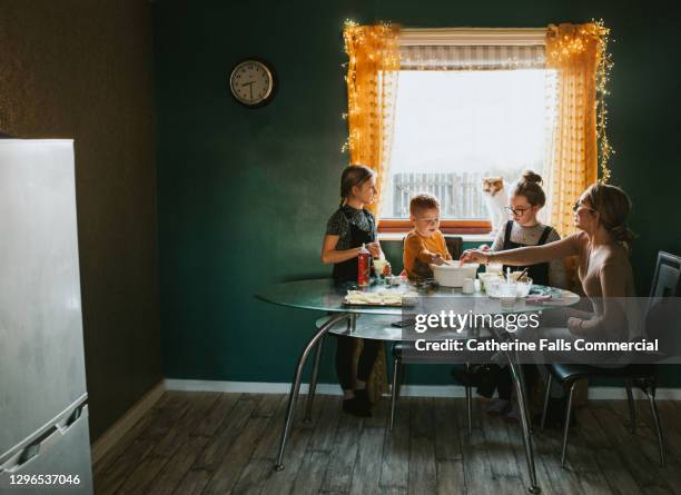 children baking at a table with mum supervising - stay at home mum ストックフォトと画像