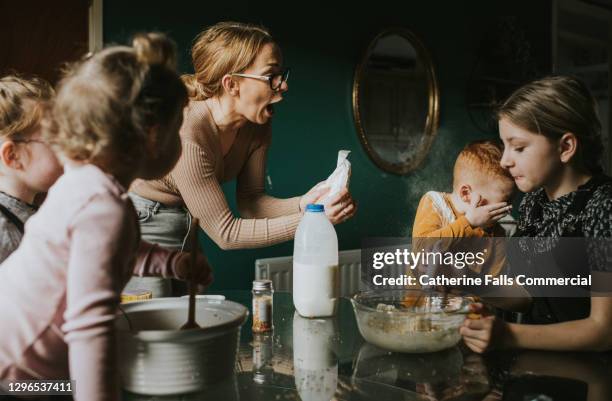 mother looks surprised as son recoils after batter splatters on him - kids misbehaving fotografías e imágenes de stock