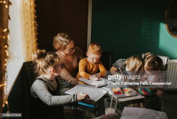 mother homeschooling her 4 children - nursery school child fotografías e imágenes de stock