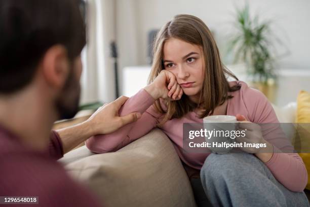 upset young adults flatmates sitting indoors and talking. - couple unhappy stockfoto's en -beelden